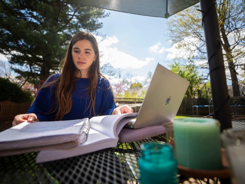 Student outside with homework